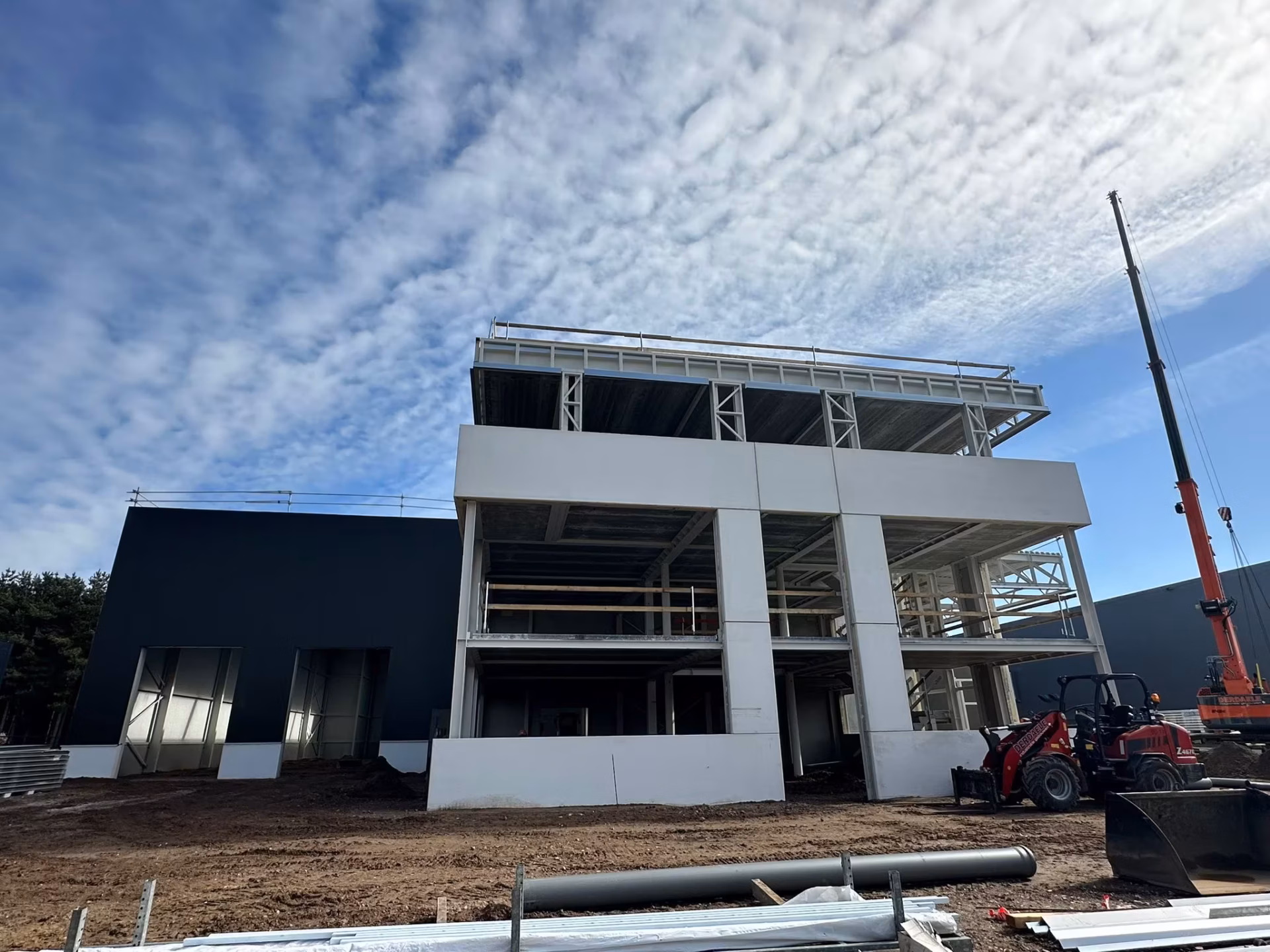 Nieuw bedrijfsgebouw voor Technical Touch Racing met magazijn, mezzanine, laadkade en kantoren, gebouwd door Derdaele+