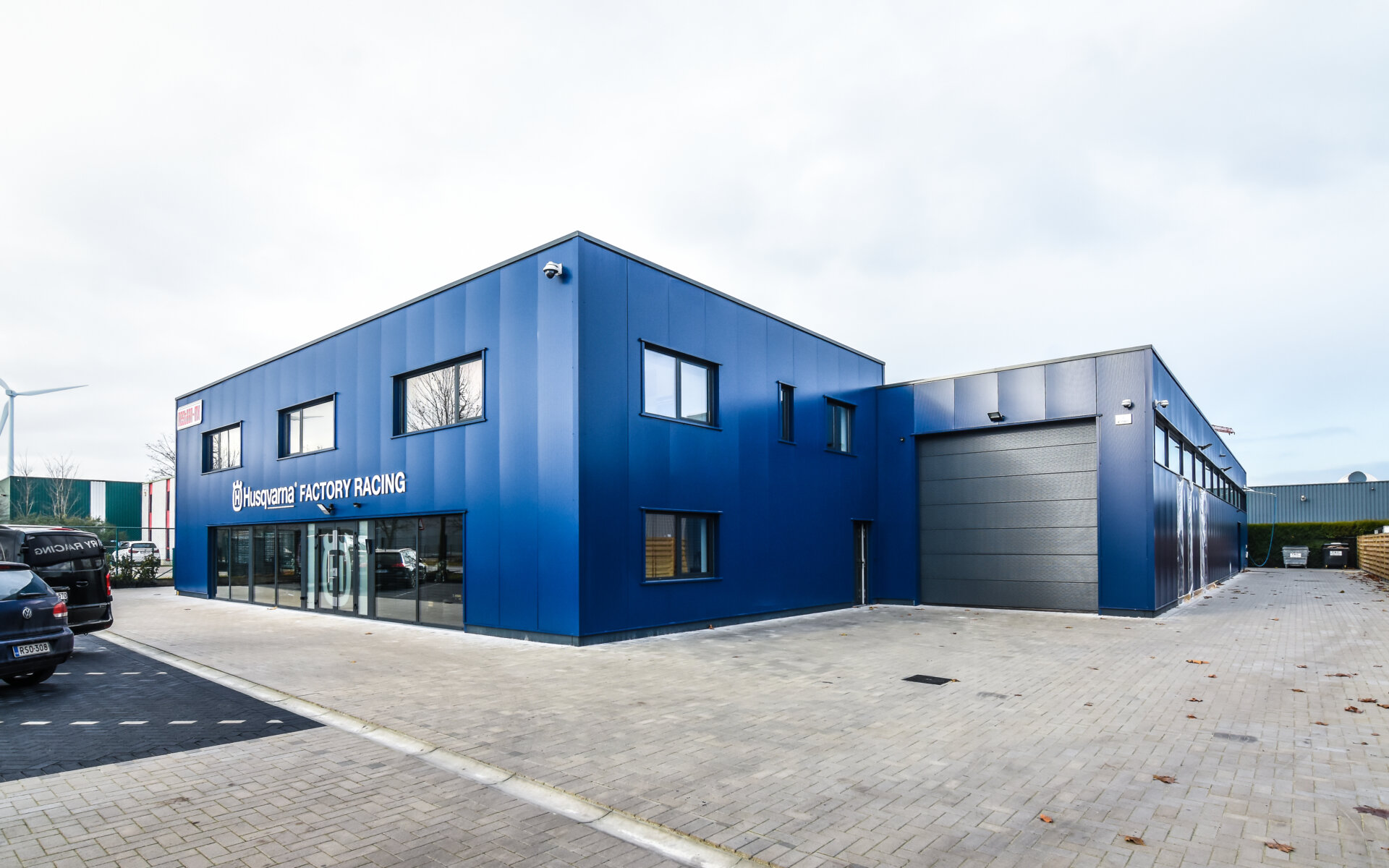Bedrijfsgebouw van Husqvarna Racing in Lommel met blauwe gevel en grote raampartijen