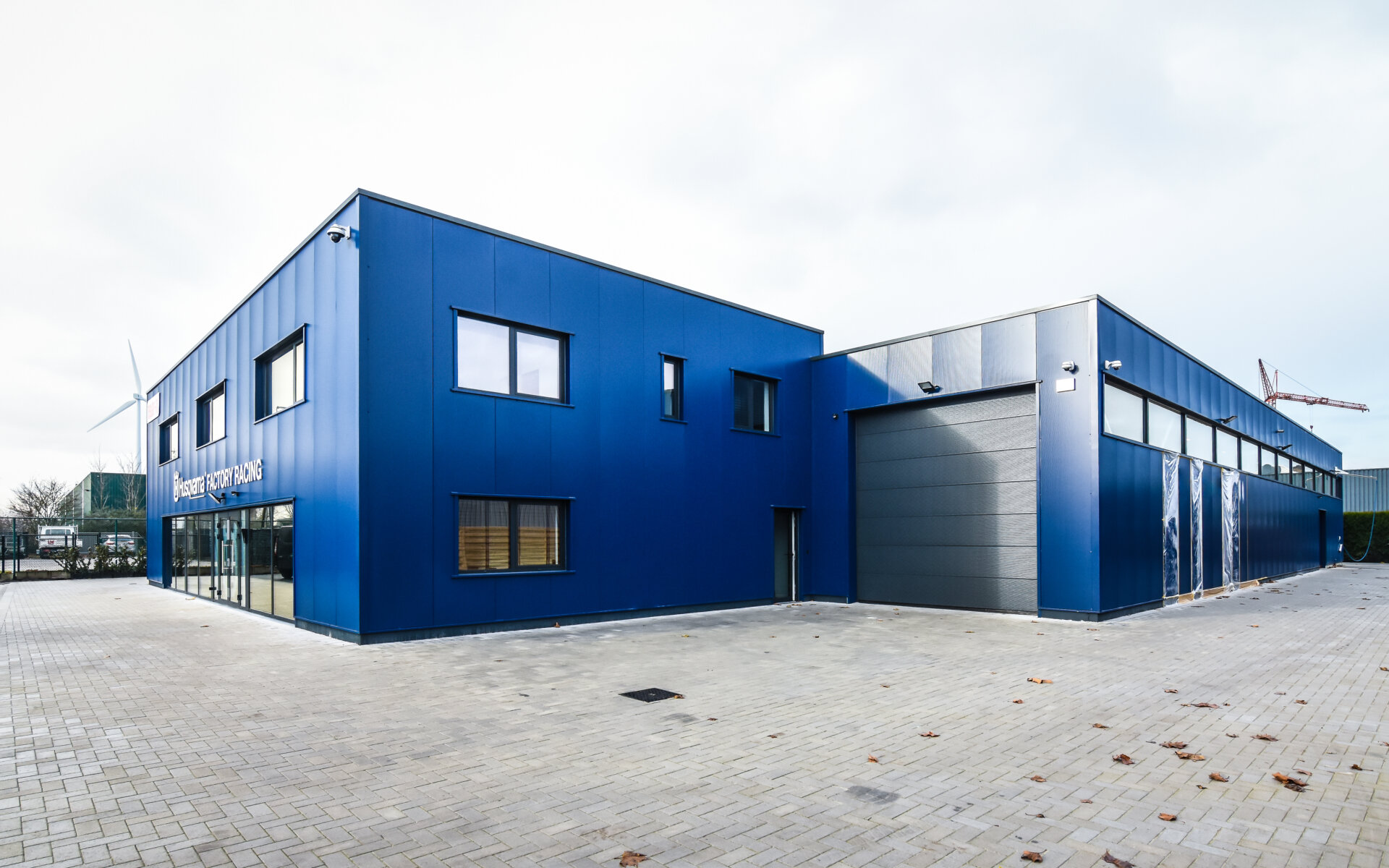Bedrijfsgebouw van Husqvarna Racing in Lommel met blauwe gevel en grote raampartijen