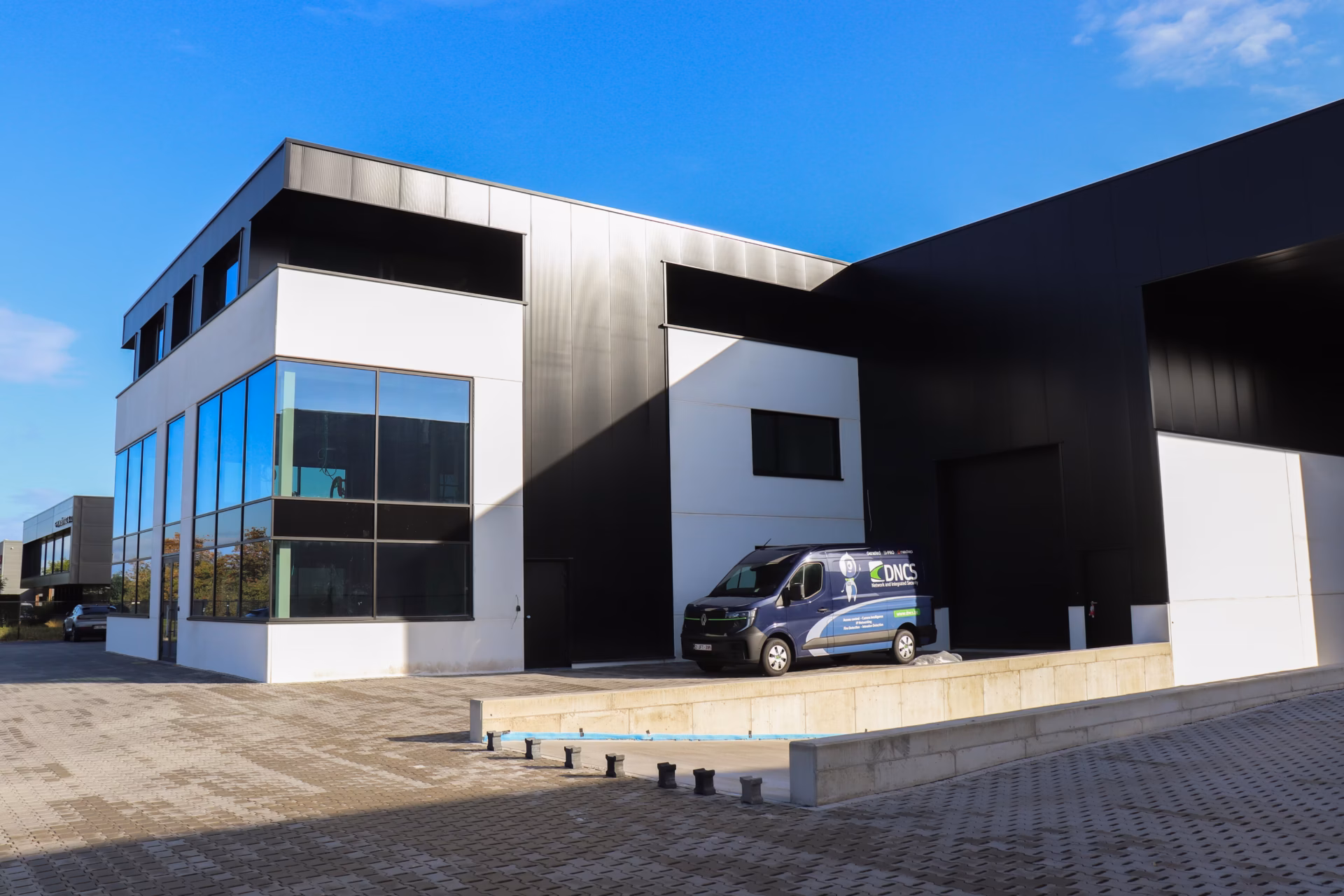 Nieuw bedrijfsgebouw voor Technical Touch Racing met magazijn, mezzanine, laadkade en kantoren, gebouwd door Derdaele+