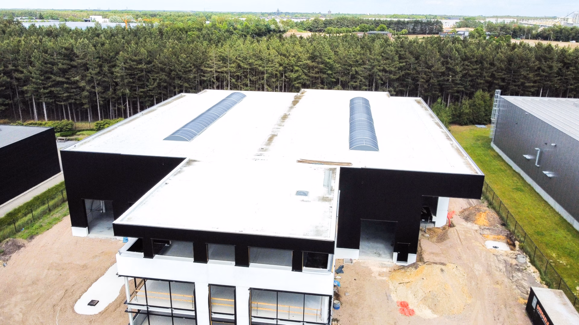 Nieuw bedrijfsgebouw voor Technical Touch Racing met magazijn, mezzanine, laadkade en kantoren, gebouwd door Derdaele+