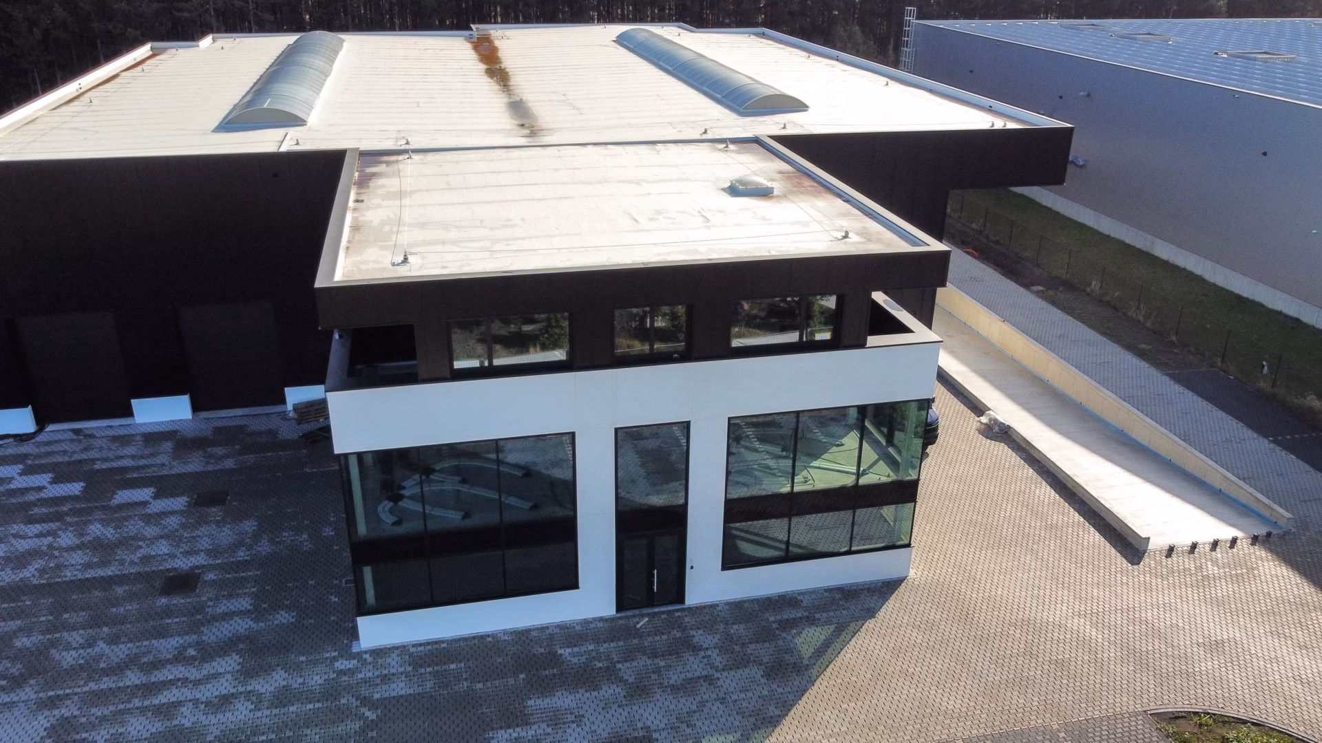 Nieuw bedrijfsgebouw voor Technical Touch Racing met magazijn, mezzanine, laadkade en kantoren, gebouwd door Derdaele+